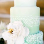Quinceanera cake, a three tiered cake with a flower on top, in pastel de xv color aqua