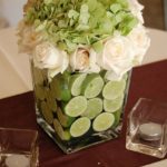 Table with a vase filled with green and white flowers for a Quinceanera arrangement