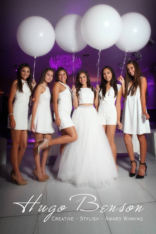 A group of women standing next to each other wearing beautiful Quinceanera dresses