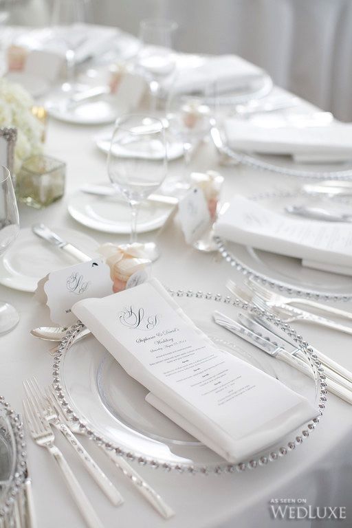 A table set for a formal Quinceanera dinner with white napkins and silverware