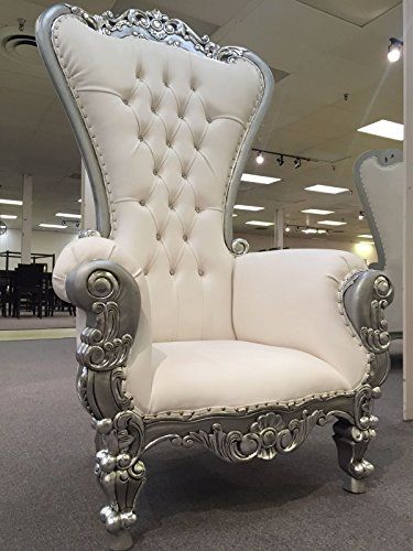 A high back Victorian chair, white and silver, sitting in a room for a Quinceanera event.