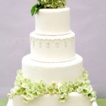 A Quinceanera cake with green hydrangea flowers on top