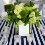 A beautiful flower bouquet arranged in a vase surrounded by candles on a table, creating a stunning floral design for a Quinceanera celebration.