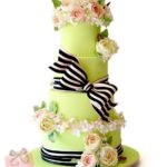 Quinceanera cake, a three tiered cake with flowers, and a bow
