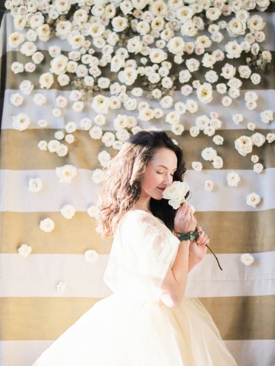A woman in a white quinceanera gown holding a flower with a floral design