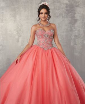 Quinceañera with a coral dress, a woman in a pink ball gown posing for a picture