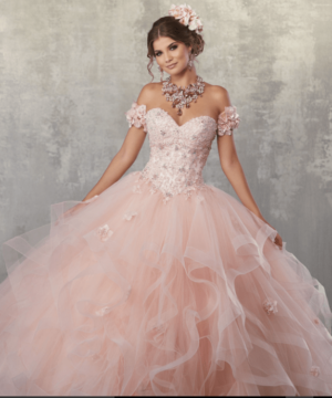A woman in a pink dress posing for a picture in Quinceañera gown Quinceañera dresses.