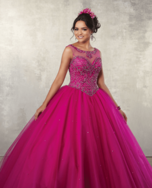 A woman in a pink Quinceanera gown dress posing for a picture