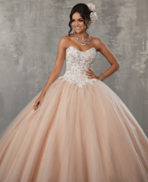A woman in a neutral quince dress posing for a picture, wearing a beautiful Quinceañera ball gown