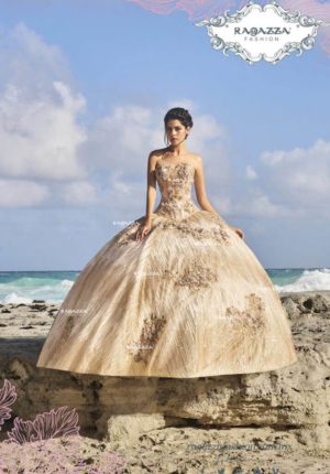 A woman in a gold Quinceañera dress sitting on a rock
