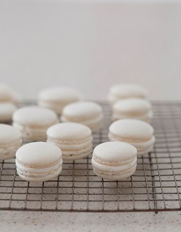 A bunch of macarons sitting on top of a cooling rack