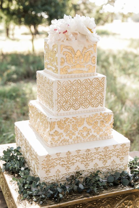 A three-tiered Quinceanera cake with gold and white decorations