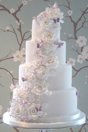 Quinceanera cake with purple flowers and butterfly decorations
