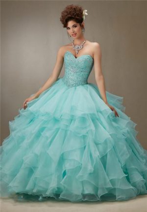 A woman in a Quinceanera gown posing for a picture with a blue dress