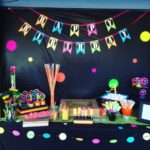 Lighting and a table topped with lots of Quinceanera-themed candies