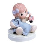 A precious moments figurine of a little girl holding a Winnie the Pooh and Eeyore stuffed animals, perfect for a Quinceanera celebration.
