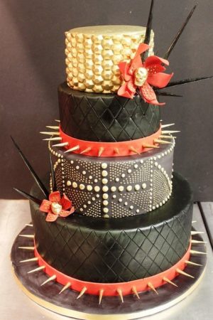 A Quinceanera-themed cake with three tiers, decorated with spikes and flowers