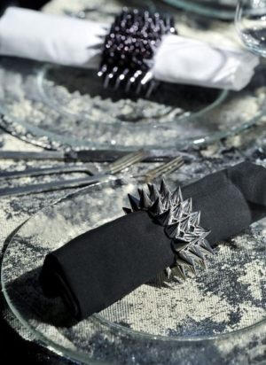 A close up of a plate with a napkin and a shoe rock, a Quinceanera theme