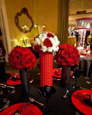 Quinceañera centrepiece featuring a black table topped with red and white flowers