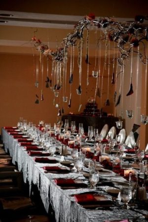 A long table set for a formal dinner with elegant Halloween decorations for a Quinceanera celebration.