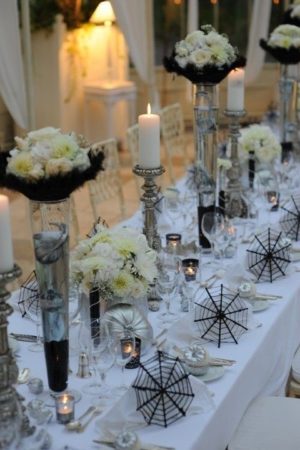 Quinceanera table decorations. A long table with white flowers and candles.