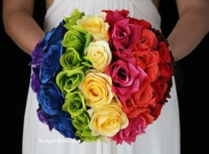 Floral design, a woman in a white dress holding a bouquet of rainbow Quinceanera flowers
