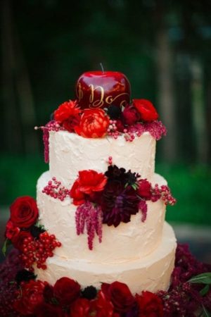 A Quinceanera-themed image featuring a Snow White cake with red flowers and an apple on top