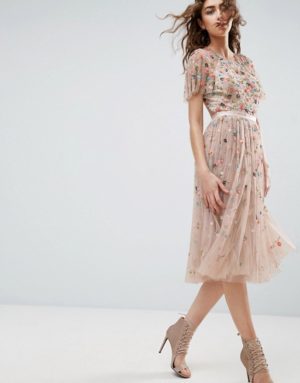 A fashion model wearing a dress and heels walking