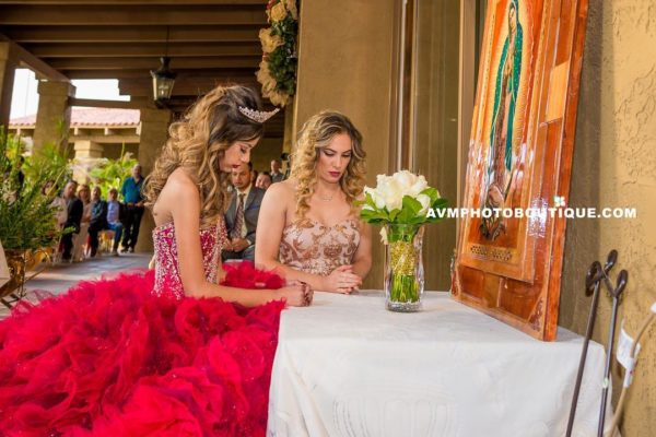 A Quinceañera bride and a couple of women sitting at a table
