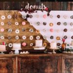 Quinceanera-themed interior design featuring a wooden table topped with lots of doughnuts