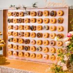 A Quinceanera themed display of doughnuts on a wooden board