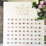 A white board with Quinceanera-themed donuts displayed on a table