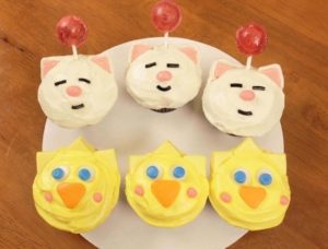 Quinceanera themed cupcakes decorated like cats and chickens on a plate