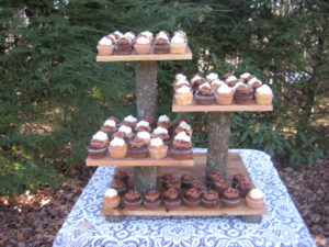 A three tiered display of cupcakes on a table at a Quinceanera celebration
