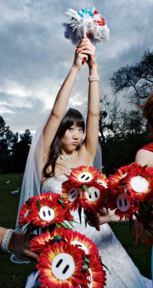 A Quinceanera holding a bouquet of red and white flowers