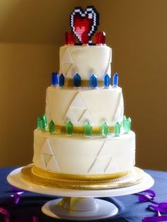 A Quinceanera themed cake on a table with confetti, resembling a video game wedding cake with three tiers.