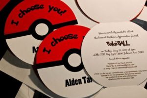 A close up of a compact disc Pokémon Sword and Shield with a poke ball on it. It's a birthday card for a Quinceanera celebration.