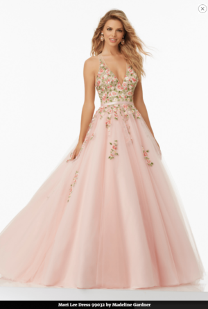 A woman in a pink Quinceanera gown posing for a picture