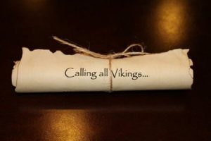 A Quinceanera theme image featuring Vikings and a roll of paper with a message on it.