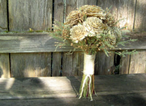 Floral design, a bouquet of flowers sitting on top of a wooden bench