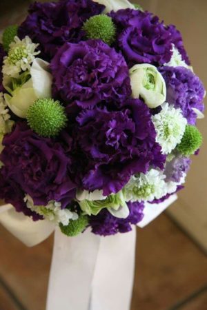 A floral design bouquet of purple and white flowers on a table for Quinceanera