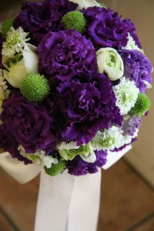 A floral design bouquet of purple and white flowers on a table for Quinceanera
