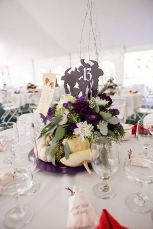 A Quinceanera-themed table centerpiece with white and purple flowers, inspired by World of Warcraft.