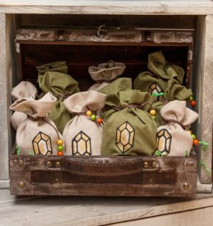 A wooden box filled with bags of stuff from The Legend of Zelda: Breath of the Wild, perfect for a Quinceanera celebration
