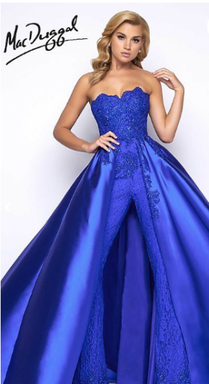 A woman in a blue Quinceanera gown by Mac Duggal posing for a picture