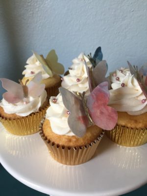 Quinceanera cupcakes, a white plate topped with cupcakes covered in frosting