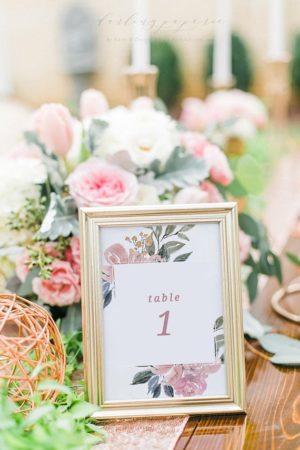 Quinceanera table name frame. A table with a picture frame and flowers.