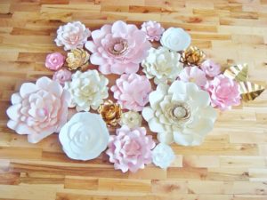 A beautiful bouquet of paper flowers arranged on a wooden floor, perfect for a Quinceanera celebration