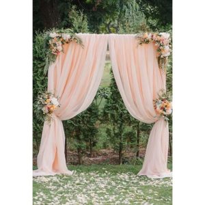 A Quinceanera arch decorated with pink and white flowers.