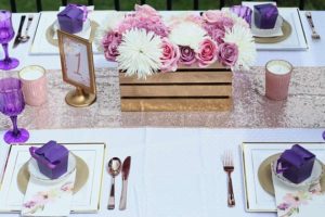 A beautiful lilac floral design with a table set for a Quinceanera celebration, including place settings and flowers.